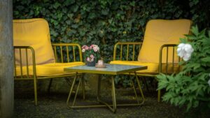 Yellow chairs and table in a lush outdoor setting in Lemgo, Germany. Perfect for summer relaxation.